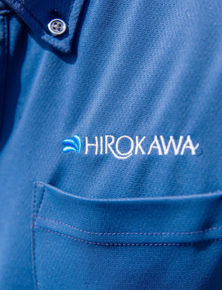 作業服の胸元に入った廣川建設工業のロゴ